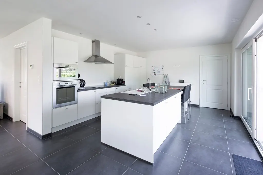 Modernized kitchen with white cabinets and a dark island