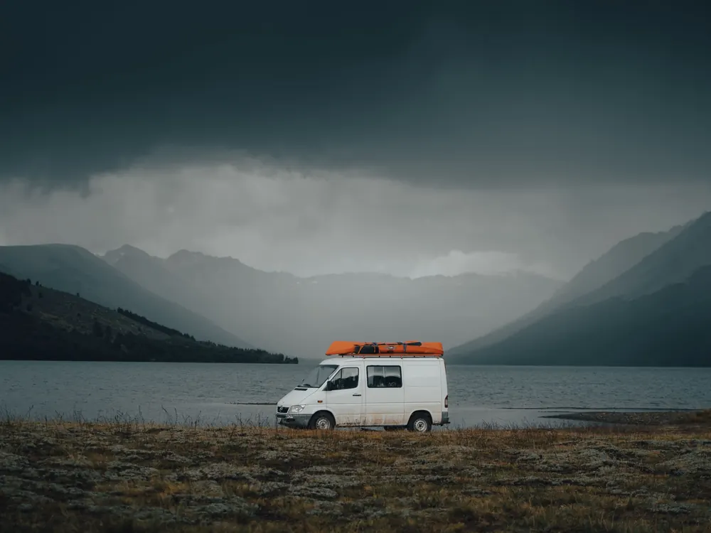 White camper van by a misty lake