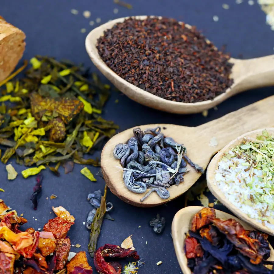 Assorted loose teas on wooden spoons