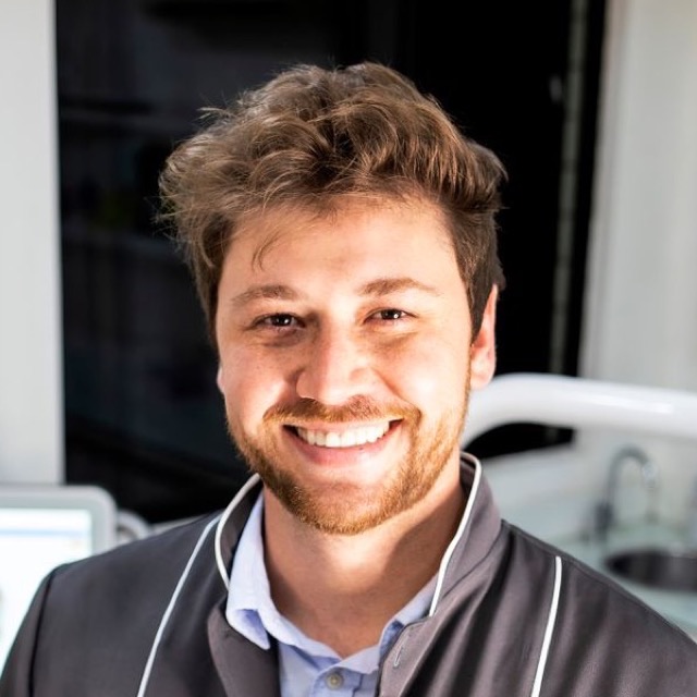 Portrait of a smiling cosmetic dentist in his dental studio